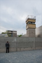 Allemagne (Germany), Berlin, Bernauer Strasse, Mur de Berlin, autour du memorial du mur, homme regardant au travers, mirador
