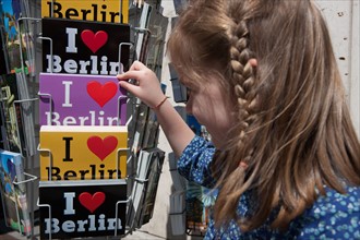 Allemagne (Germany), Berlin, Porte de Brandebourg, Friederichstrasse, enfant choisissant des cartes postales,