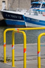 Port en Bessin Huppain, quai avec barrières jaunes et chalutiers amarrés
