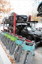 Paris, Vélib' bike and truck with a car carrier trailer