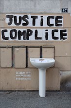 Paris, bulky waste on public road and fly posting that reads 'justice complice'