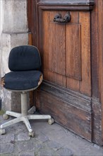 Paris, office chair laid in front of a carriage door