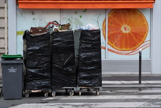 Paris, magasin d’alimentation et poubelles sorties