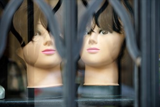 Mannequins behind a metal curtain