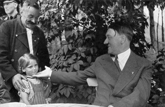 Adolf Hitler.  "Hier, mein Führer, ist mein Enkelkind''. Un père présente sa fille à Hitler.