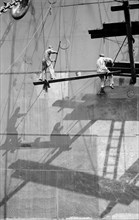 Two men painting a ship in the Royal Albert Dock, Canning Town, London, c1945-c1965