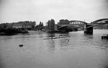 A rowing eight approaches Barnes Bridge, Chiswick, London, c1945-c1965