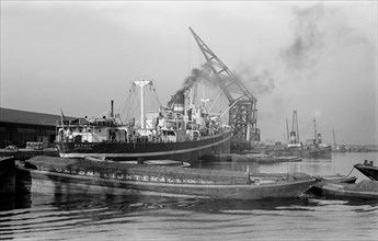 A crane unloads cargo from the 'Makalla' in Tilbury Docks, Essex, c1945-c1965