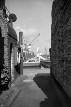 A view between harbour buildings in London docks, 1937
