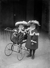Two children and a pram, c1896-c1920
