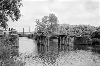 A group of men contemplate a footbridge over the River Medway at Barming, c1945-c1965