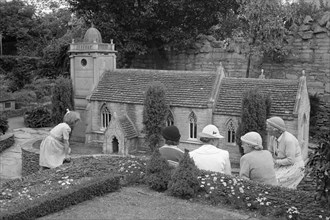 A group of women and a child admire the church in the model village at Corfe Castle, c1945-c1965