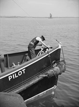 A man working on the bow of a River Thames pilot boat, c1945-c1965