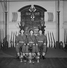 Three soldiers are posed in front of the Honourable Artillery Company's war memorial, c1945-c1965