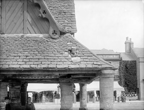 Boy poking his head through the roof of the 17th-century Buttercross, Witney, Oxon, c1860-c1922