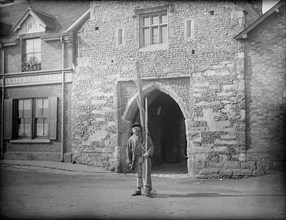 A shrimper with his equipment standing in front of Old Fishers Gate, Sandwich, Kent, c1860-c1922