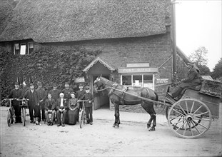 Postmen and other staff pose outside the post office in Byfield, Northamptonshire, c1873-c1923