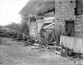 A woman sawing logs, Godstow, Oxford, Oxfordshire, 1900