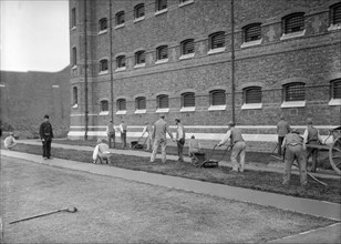 Prisoners cutting grass at Wormwood Scrubs prison, London, c1900-1950