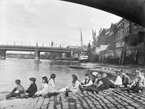 Children on the cobbled causeway under Southwark Bridge, London, c1930. Artist: George Davison Reid