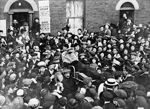 Sylvia Pankhurst leaving the East End of London in a bath-chair, June 1914. Artist: Unknown