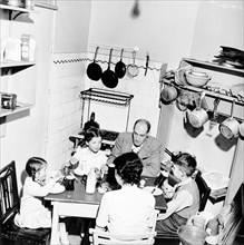 A family dining in their London home, c1950s. Artist: Henry Grant