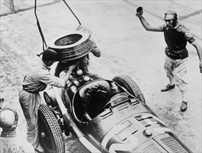 Tazio Nuvolari waiting for his car to be refuelled, c1930s(?). Artist: Unknown