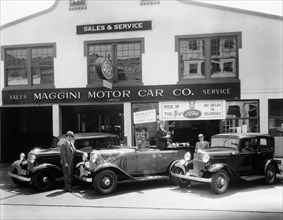 1932 Ford V8 in front of a car showroom, (c1932?). Artist: Unknown