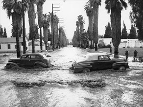 Cars on a flooded road in California, USA. Artist: Unknown