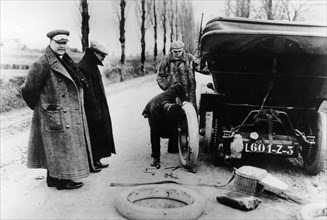 Lord Northcliffe's chauffeur changing a tyre, (c1908?). Artist: Unknown
