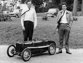 Two men standing by a miniature Sunbeam pedal car, 1960s. Artist: Unknown