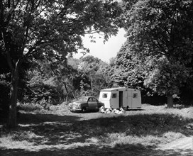 A family relaxing on holiday with their 1951 Vauxhall Wyvern and caravan, (1951?). Artist: Unknown