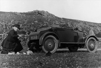 A woman picnicking next to her air-cooled Rover 8, c1919-c1925. Artist: Unknown