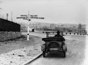 Car near a road sign, Bromley, Kent, 1920s. Artist: Unknown