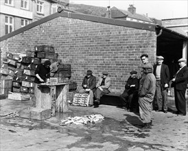 Gutting fish outside a warehouse in Whitby, North Yorkshire, 1959. Artist: Unknown