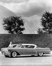 Woman with a 1957 Cadillac coupe de ville, (c1957?). Artist: Unknown