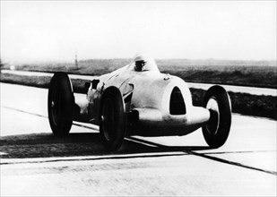 Bernd Rosemeyer in Auto Union record-breaking car, 1937. Artist: Unknown