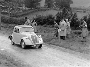 1937 Fiat 500 Coupe competing in the Welsh Rally. Artist: Unknown