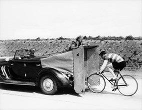 Cyclist training behind an Auburn car, c1935. Artist: Unknown
