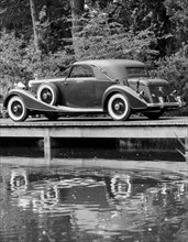A 1933 Hispano-Suiza K6 reflected in a lake. Artist: Unknown
