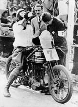 Van Horne taking a drink whilst on his Norton bike. Artist: Unknown
