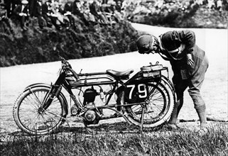 Norman Black repairing a punture on his Norton bike, 1920. Artist: Unknown