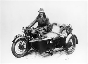 Man riding an AJS motorbike with a woman in the sidecar, 1939. Artist: Unknown