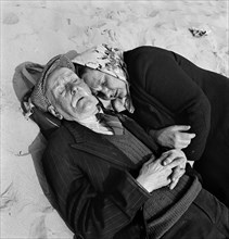 An elderly couple doze on the beach, Blackpool, c1946-c1955