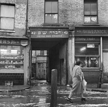 A woman walks past the Chevrah Shass Synagogue, Whitechapel, London c1946-c1959