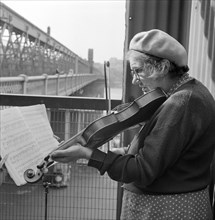 Busker playing the violin, Hungerford Bridge, Lambeth, London, c1946-c1959