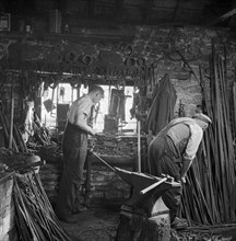 Men working in a blacksmith's workshop, c1946-c1959