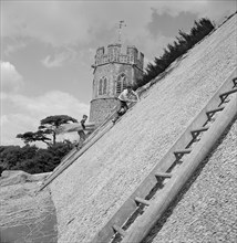 Thatchers at work on the roof of St Peter's Church, Theberton, Suffolk, 1956 Artist