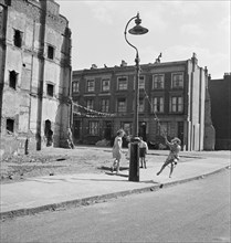 Children swinging on a lamppost, London, 1960-1965