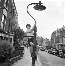 Boy climbing a lamppost, Kentish Town, London, 1960-1965